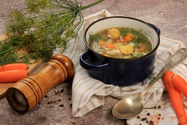 Fresh fish soup with vegetables in bowl on dark background, top view