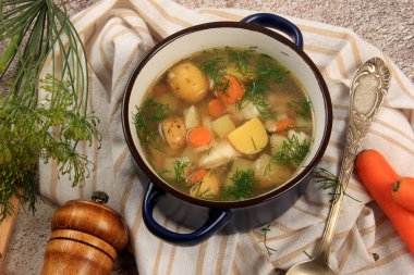 Fresh fish soup with vegetables in bowl on dark background, top view