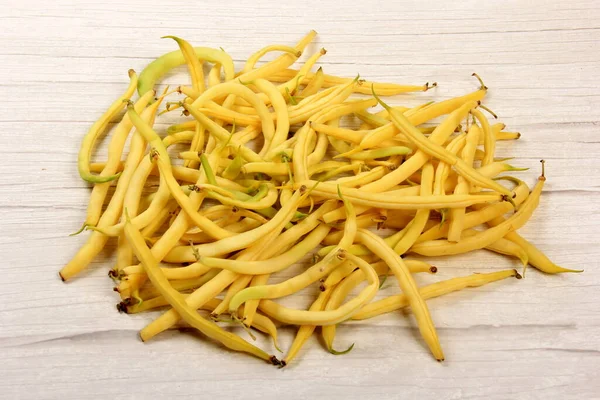 Fresh yellow beans on a wooden table background