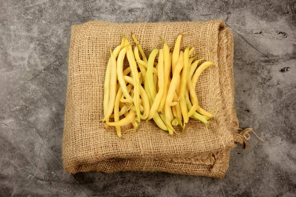 Fresh yellow beans on a wooden table background
