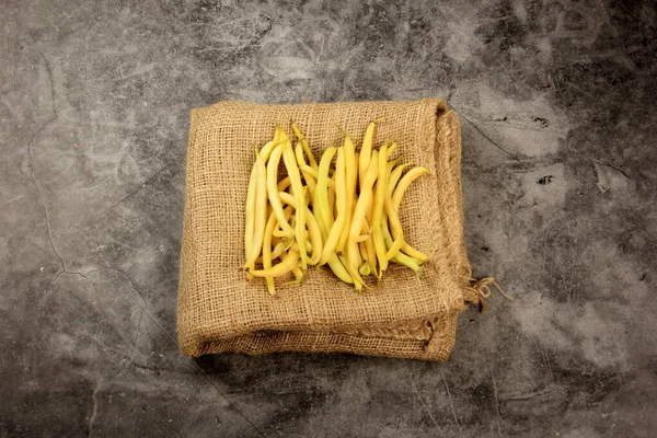 Fresh yellow beans on a wooden table background