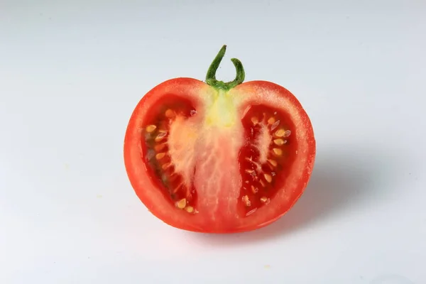 halved red tomato on a white background. sliced ripe tomato