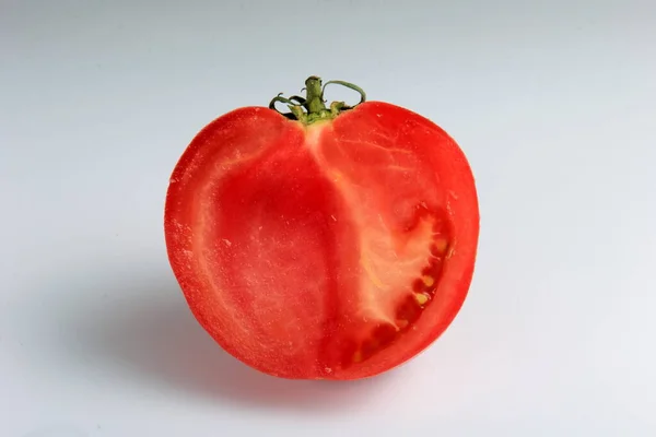 halved red tomato on a white background. sliced ripe tomato