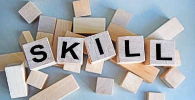 Tahta küplere SKILL yazılışı hafif bir arkaplanda izole edilmiş, iş ve finans kavramı.