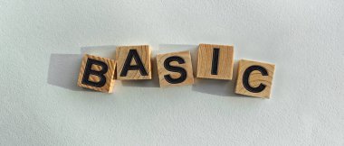 BASIC yazısını tahta küplerin üzerine, arka planda, masa üstü görünümünde. Firma ve markanın tanıtımı için grafiksel kaynaklar.