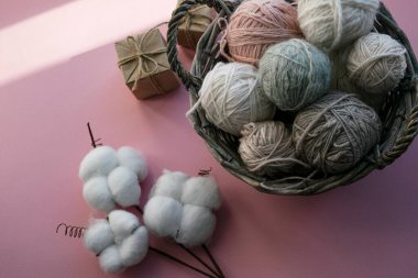 İçinde iplik yumakları olan sepet. Hediye kutuları. Tatil için dekorasyon. Hassas renkler, pembe arkaplan.