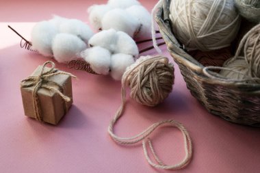 İçinde iplik yumakları olan sepet. Hediye kutuları. Tatil için dekorasyon. Hassas renkler, pembe arkaplan.