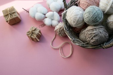 İçinde iplik yumakları olan sepet. Hediye kutuları. Tatil için dekorasyon. Hassas renkler, pembe arkaplan.