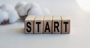 Hafif arkaplanda izole edilmiş tahta küplere Başlat yazılıydı. Tahta küp üzerinde kelime oluşturma kavramı. İş, ekonomi ve finans kavramı.