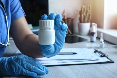 Genç bir doktor ya da eczacı kız hastaya ilaç sunar. Evde tıbbi hizmetler sağlanıyor. Haplar ellerde. Sağlık hizmetleri kavramı.