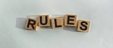 The inscription RULES on wooden cubes on a light background, on the table top view. Graphic resources for promoting the concept of the firm and brand.