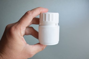 A jar of pills in the hand of a young doctor, a girl. healthcare concept.