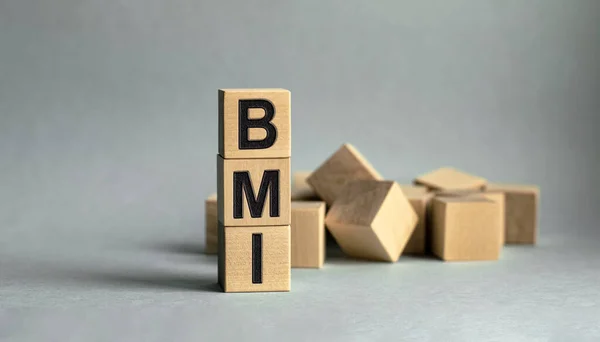 Tahta küplere işyeri ve finans kavramının izole edilmiş BMI yazılıdır..