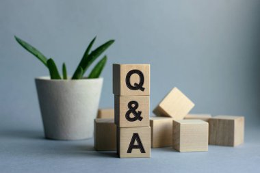 Tahta küplere yazılmış soru-cevap yazısı mavi arka planda izole edilmiş, iş ve finans kavramı..