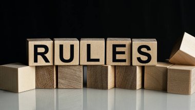 Tahta küplerdeki yazıt kuralları karanlık bir arkaplanda izole edilmiş, iş ve finans kavramı.