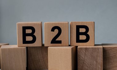 B2B, beyaz arkaplanda tahta küplerin üzerindeki yazı.
