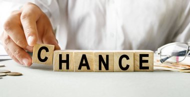 Tahta küplerin dokusunda şans yazıtları. Bir iş adamı elinde bir küp tutuyor. Finansal, ticari ya da ekonomik tema üzerine bir yazı.
