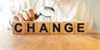 Tahta küplerin dokusundaki yazıyı değiştirin. Bir iş adamı elinde bir küp tutuyor. Finansal, ticari ya da ekonomik tema üzerine bir yazı.