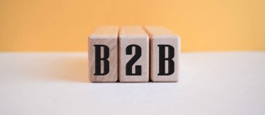 Açık turuncu arkaplandaki tahta küplere B2B yazılıydı.