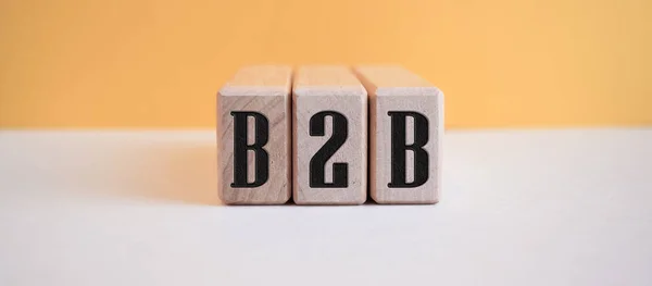 Açık turuncu arkaplandaki tahta küplere B2B yazılıydı.