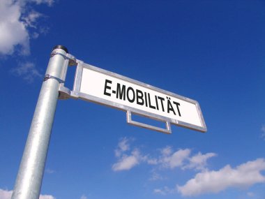 Aşılamak için Almanca E-Mobilite gösteren mavi gökyüzü tabelalı sokak tabelası 