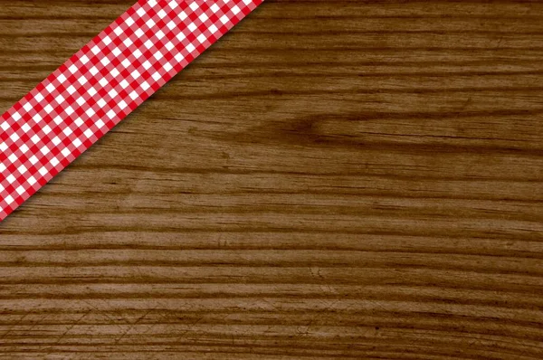 古い木のテーブルと赤い白いチェッカー付きのテーブルクロス — ストック写真