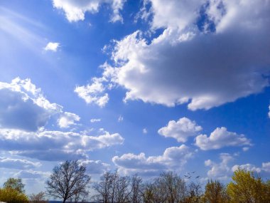 Güzel mavi gökyüzü, bulutların arkasında güneş ışığı.
