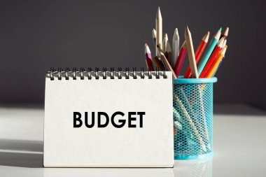 Bütçe - renkli kalemlerle dolu bir deftere yazı.