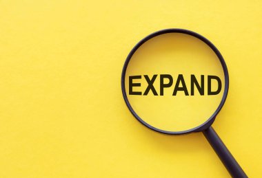 ExPAND kelimesi sarı arkaplanda bir büyüteç üzerine yazılmıştır..