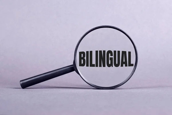 Gri arkaplanlı GILINGUAL harfli büyüteç.