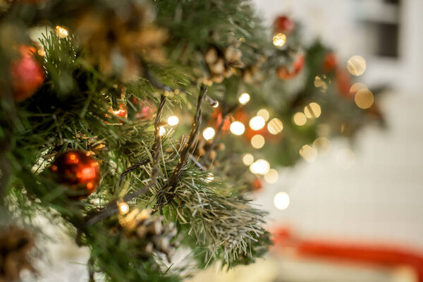 Christmas outdoor background with fir tree branches, decorations and blurred lights on back. Selective focus. Copy space
