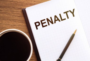 Beyaz not defterinde bir fincan kahve, bir kalem ve bir bardak bardakla birlikte.