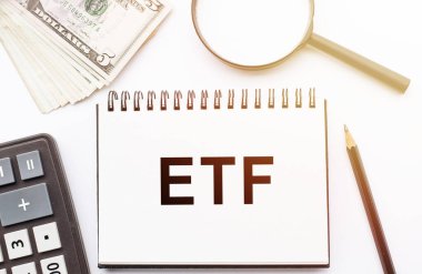 ETF Değişim Fonu ile ilgili notları ve araçları olan defter ofis masasında yatıyor