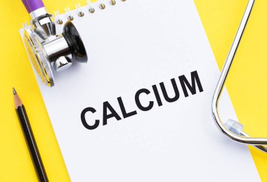 Kalsiyum. Metin, sarı arkaplanda steteskop bulunan tıbbi bir deftere yazılmış..
