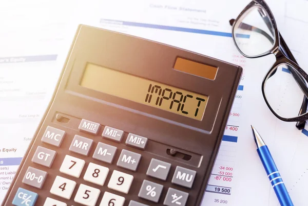 Word Impact Auf Der Anzeige Eines Rechners Auf Finanzdokumenten — Stockfoto