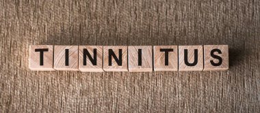 Tahta küplerle yazılmış Tinnitus Kelimesi
