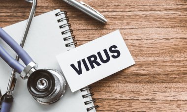 Tahta doktorun masasında VIRUS mesajı olan bir kart..