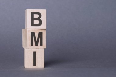 BMI - Vücut Kütle İndeksi, tahta bloklara yazılmış metin, gri arkaplan üzerine.