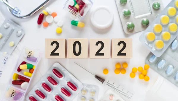 New Year 2022 Wooden Cubes White Table Coloured Medical Pills — Stock Photo, Image