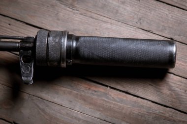 Silahlar için siyah susturucu. Tahta arka planda bir saldırı tüfeğinin ucundaki susturucu.