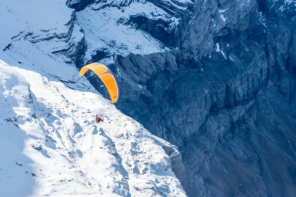 Αλεξίπτωτο πλαγιάς πάνω από το παγετώνα Diablerets σε 3000 μέτρα πάνω από την επιφάνεια της θάλασσας στην Ελβετία σε μια χειμωνιάτικη ημέρα — Φωτογραφία Αρχείου