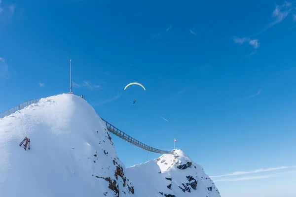 Két hegy függőhíddal összeköti őket egy személlyel az égen, aki átsiklik a Diablerets gleccser 3000 felett. — Stock Fotó