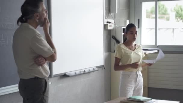Latin tinédzser diák felolvas egy kompozíciót az osztálytársaknak és a tanárnak. Spanyol lány az osztályteremben. — Stock videók