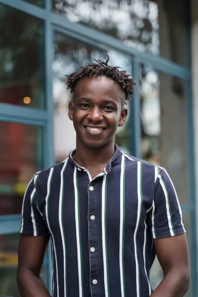 Portrett av lykkelig, selvsikker afrikansk ung mann med trendy hverdagsantrekk som ser mot kameraet – stockfoto