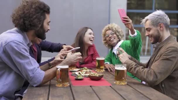 Skupina šťastných multietnických přátel s chytrými telefony fotit jídlo a pití, a selfie ve venkovním baru sdílet to na sociálních sítích aplikací — Stock video