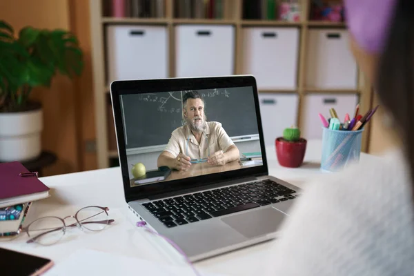 Ugjenkjennelig elev som ser på online videokurs med matteprofessor hjemmefra – stockfoto