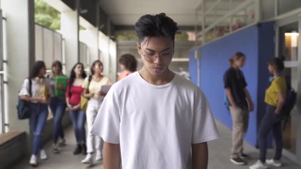 Sad Asian teenager victim of bullying at the High School. Abused Bullied student is hit by boy while group of classmates make fun of him. Violence and racism problem in Education — 비디오
