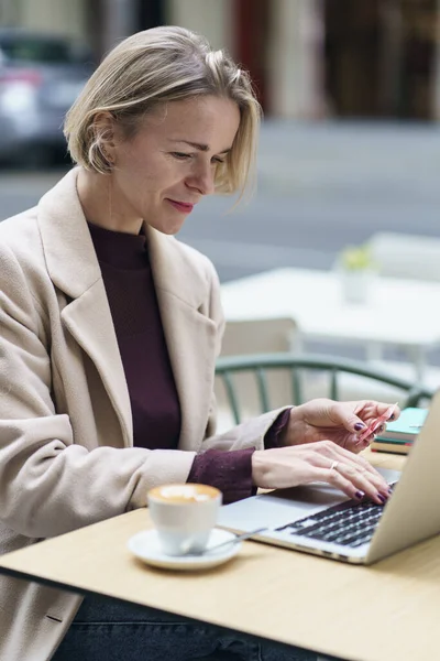 Blond kvinne som jobber med laptop og bruker kredittkort til nettbankinvesteringer – stockfoto