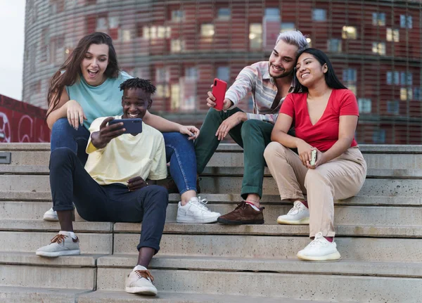 Groupe d'amis multiethniques heureux prenant selfies partage de contenu de médias sociaux sur le téléphone intelligent. Divers jeunes s'amusent à utiliser Internet dans une ville moderne de Barcelone — Photo