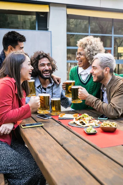 Groep jongeren die samen een biertje drinken in brouwerij bar - Vriendschapsconcept met jongeren die samen tapas eten — Stockfoto